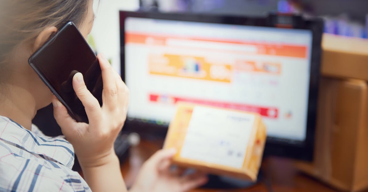 Een vrouw is bezig met multitasken: ze gebruikt haar telefoon en controleert thuis een online aankooppakket.